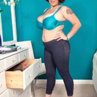 Overweight dark haired solo female Elaina Gregory unsheathes her melons in jeans and heels