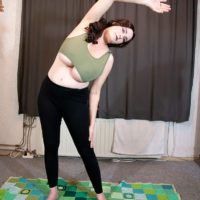 Beguiling redhead stunner Cleo lets out her massive tits during a yoga routine